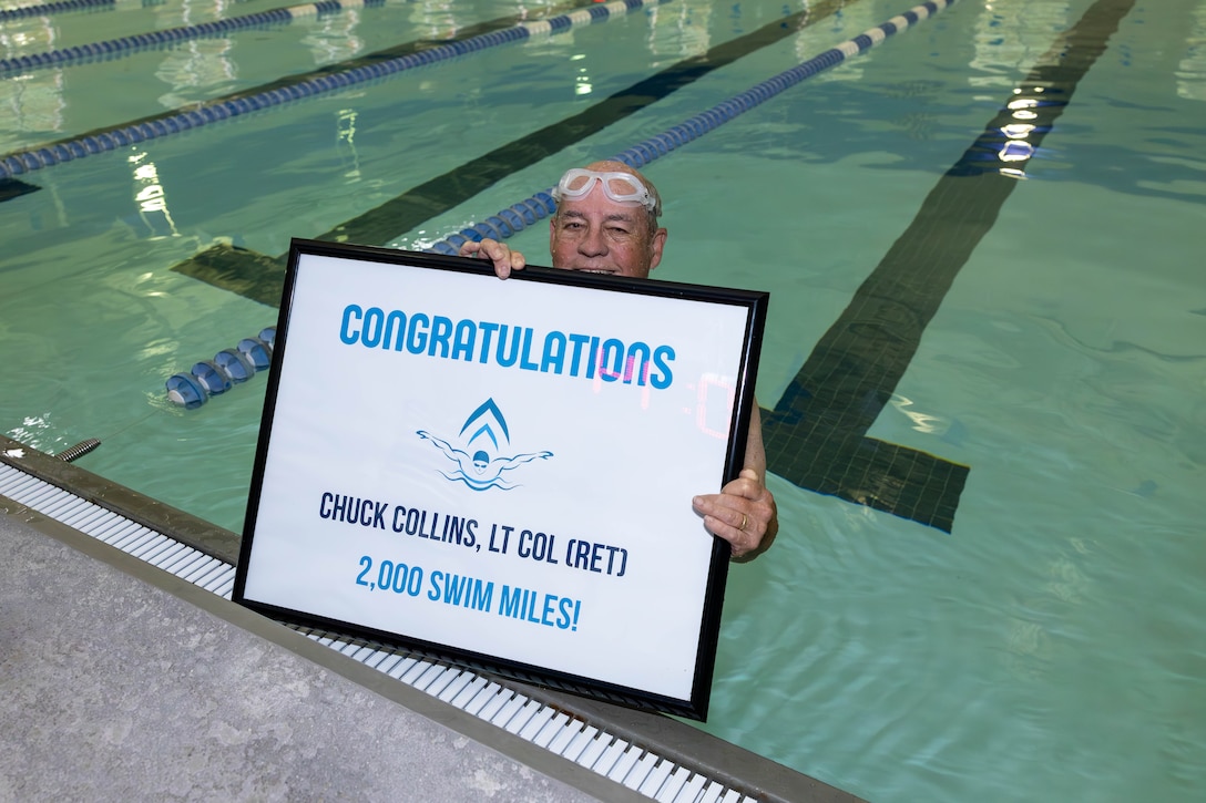 U.S. Marine Corps Lt. Col. Chuck Collins (retired), poses for a photo after completing his 2,000th mile swim as part of the Marine Corps Community Services Devil Fish Program at the Wallace Creek pool on Marine Corps Base Camp Lejeune, North Carolina, Sept. 30, 2025. Collins, a former naval aviator and executive officer of Marine Corps Air Station New River, credits swimming with preserving his health and promoting lifelong fitness and dedicates the milestone to the Marine Corps for instilling the discipline that carried him through every lap. (U.S. Marine Corps photo by Lance Cpl. Erica S. Padgett)
