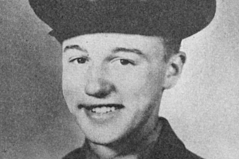 A man wearing a military dress uniform and cap poses for a photo.