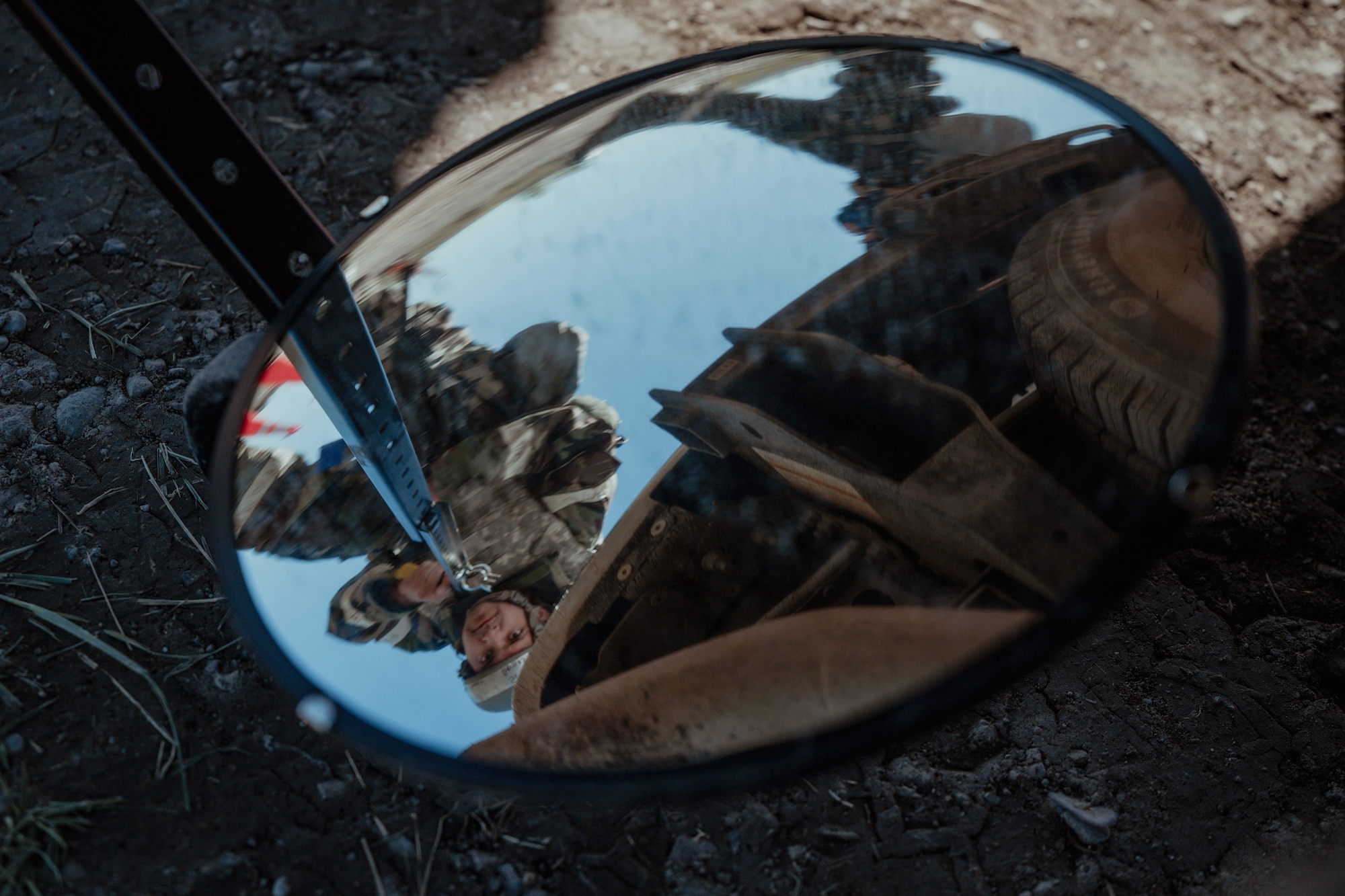 A mirror being held under a vehicle.