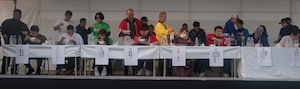A group of people eat udon in a competition.