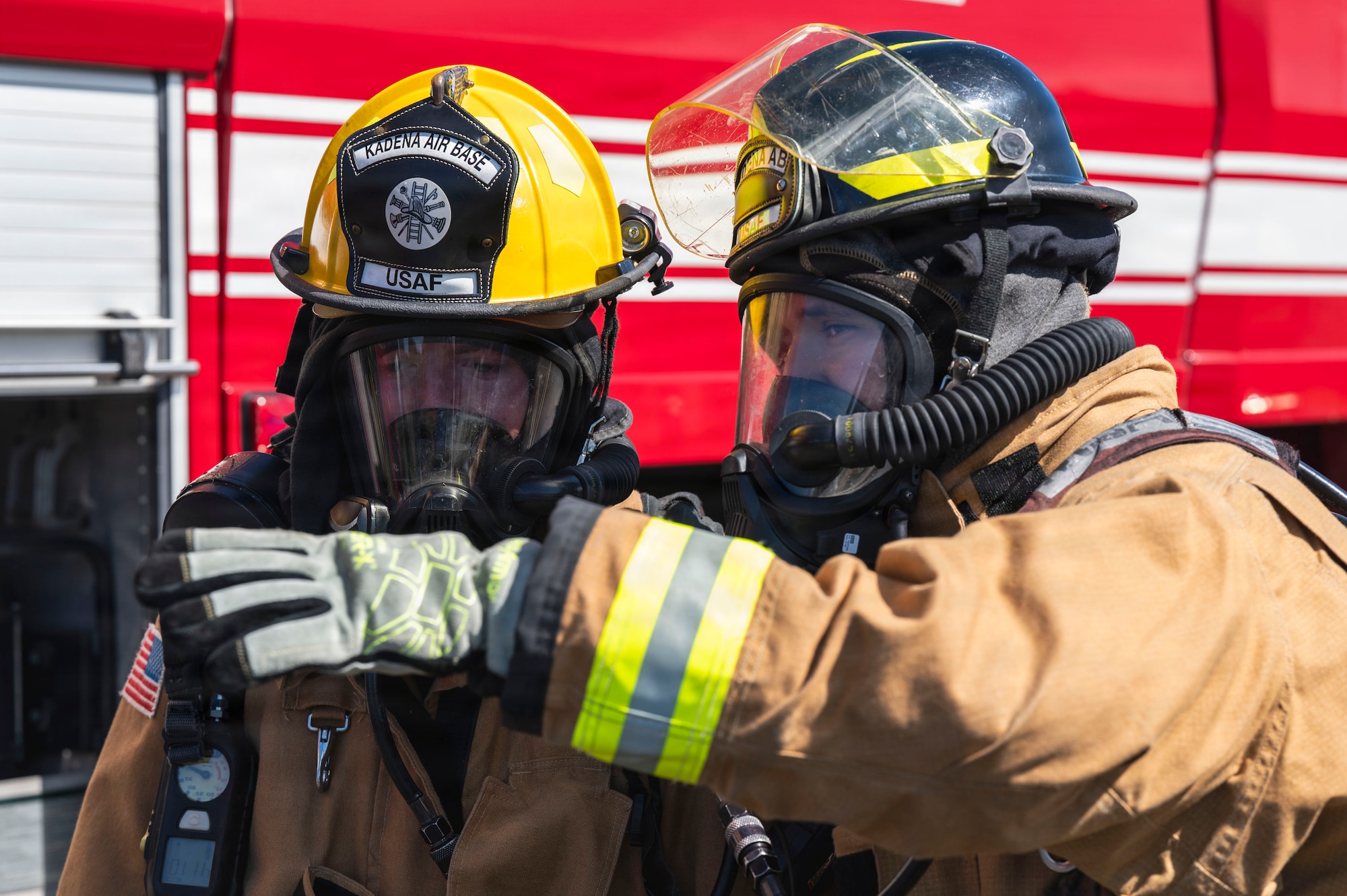 U.S. Air Force Airman 1st Class Ethan Cox, left, and Senior Airman Jonathan Rondon-Cruz, 18th Civil Engineer Squadron Fire and Emergency Services driver operators, practice coordinated firefighting procedures during base-wide operational readiness exercise BH 26-1 at Kadena Air Base, Japan, Nov. 6, 2025.