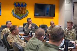 Airmen sit around a conference table