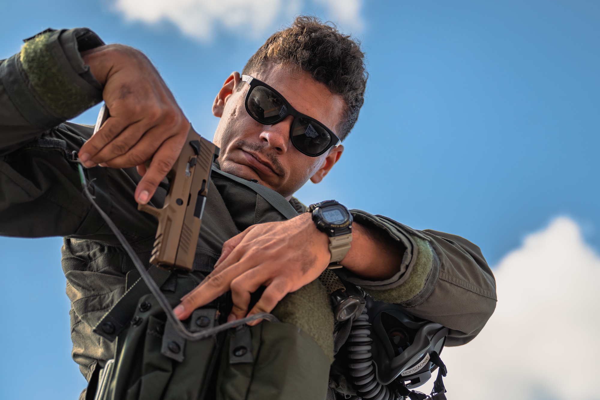 U.S. Air Force 1st Lt. Sam Delacruz, 95th Fighter Squadron F-35A Lightning II pilot, holsters a M18 handgun at Tyndall Air Force Base, Florida, Oct. 17, 2025.