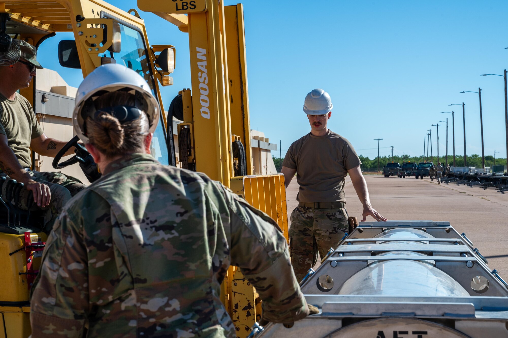 U.S. Air Force Airmen assigned to the 7th Munitions Squadron unload a Joint Air-to-Surface Standoff Missile container during exercise Death Strike 25-03 at Dyess Air Force Base, Texas, Sept. 22, 2025. The exercise focused on mass production, pallet build-up, processing of personnel and equipment, and accelerated movement of training munitions across the installation. (U.S. Air Force photo by Airman 1st Class Adrien Tran)