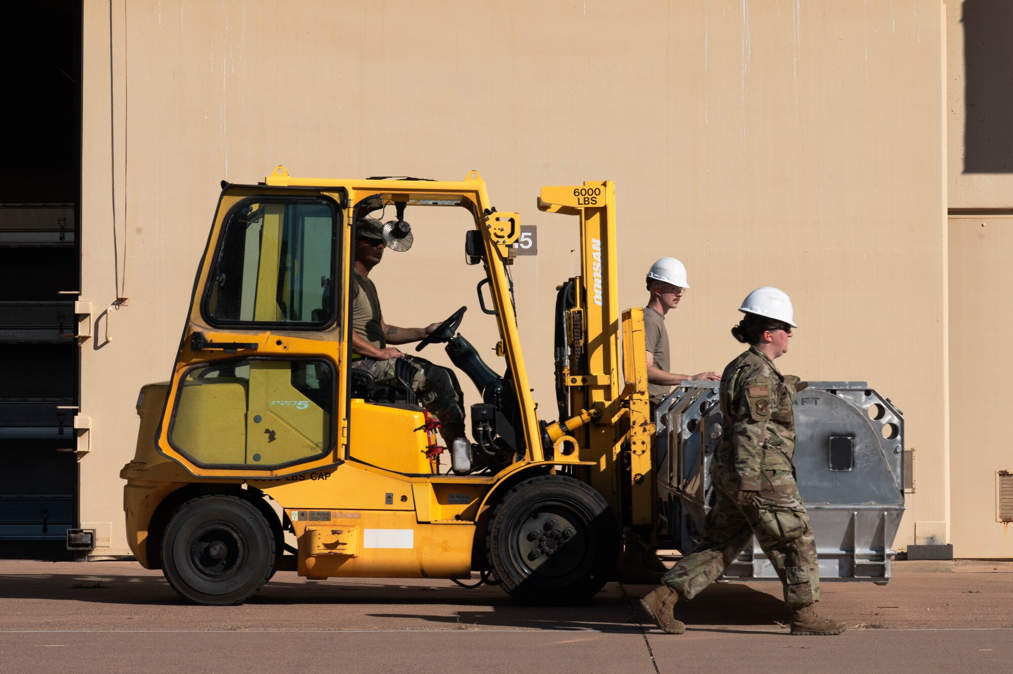 U.S. Air Force Senior Airmen Cody Garza and Daniel McNulty, 7th Munitions Squadron conventional maintenance crew chiefs, and Senior Airman Amanda McKibben, 7th MUNS conventional maintenance technician, move inert Joint Air-to-Surface Standoff Missiles during exercise Death Strike 25-03 at Dyess Air Force Base, Texas, Sept. 22, 2025. The 7th MUNS tasked itself with rapidly moving its entire JASSM stockpile as part of contingency training during the exercise. (U.S. Air Force photo by Airman William Neal)