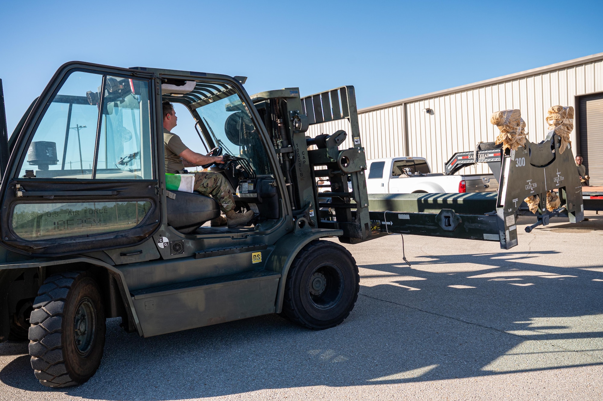 U.S. Air Force Staff Sgt. Zakkary Bunting, 7th Munitions Squadron aircraft armament systems technician, places a load launch adapter onto a trailer during exercise Death Strike 25-03 at Dyess Air Force Base, Texas, Sept. 22, 2025. The exercise tested Airmen’s ability to sustain large-scale munitions generation and meet combat-ready timeliness under simulated wartime conditions. (U.S. Air Force photo by Airman 1st Class Adrien Tran)