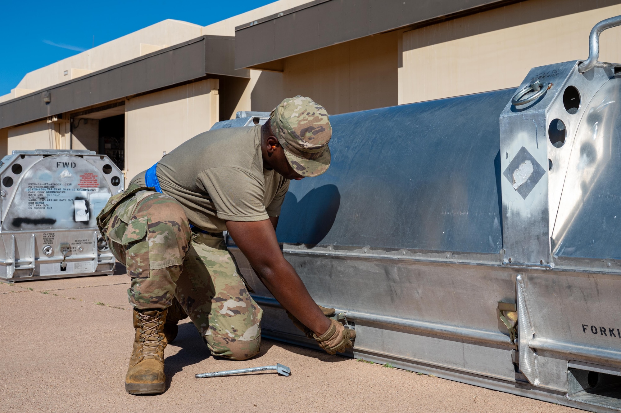 U.S. Air Force Airman Nahan Jones, 7th Munitions Squadron trailer maintenance apprentice, unfastens the lock on a Joint Air-to-Surface Standoff Missile container during exercise Death Strike 25-03 at Dyess Air Force Base, Texas, Sept. 22, 2025. The exercise emphasized precision and speed in preparing long-range munitions for immediate deployment. (U.S. Air Force photo by Airman 1st Class Adrien Tran)