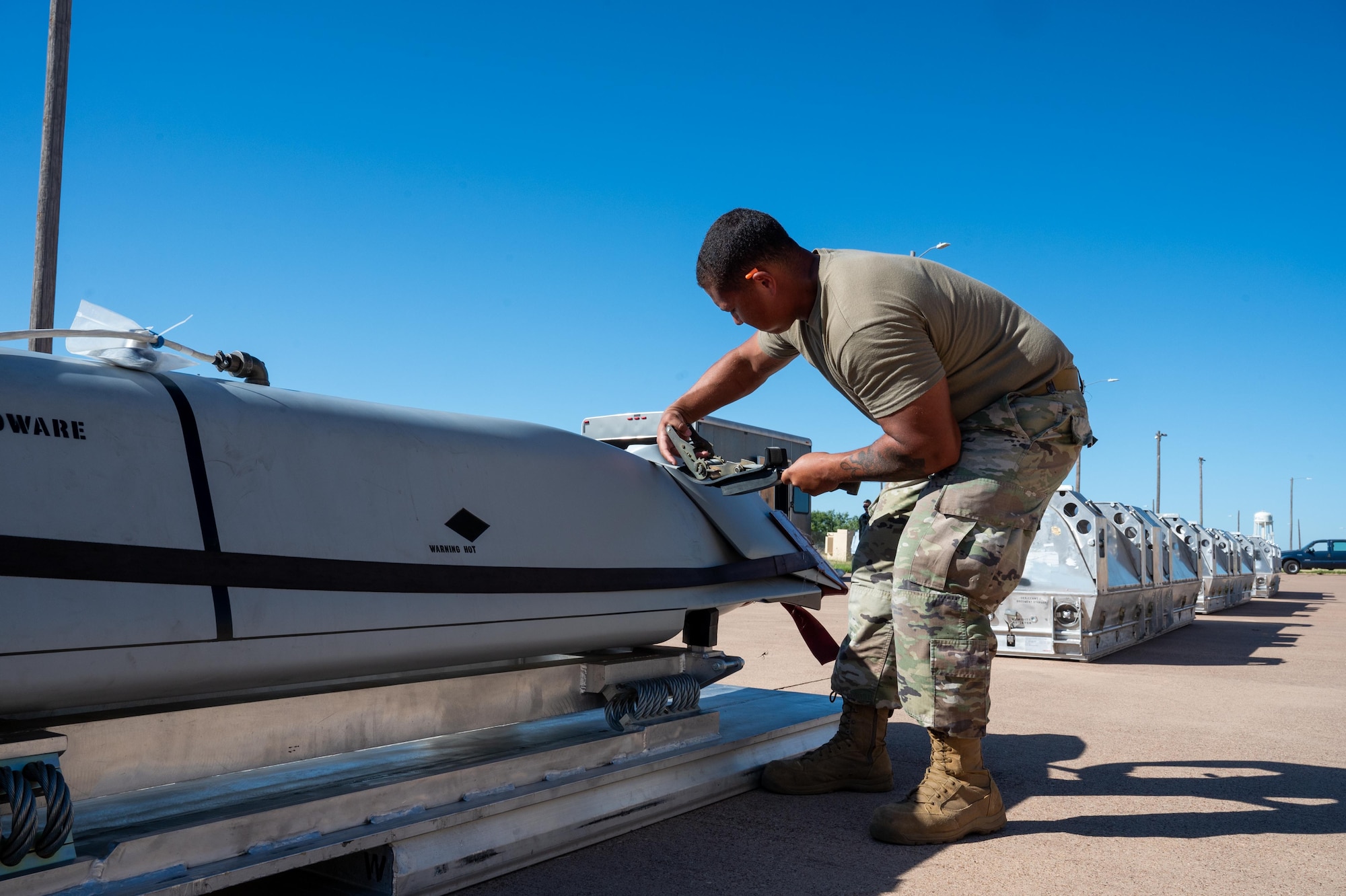 U.S. Air Force Staff Sgt. Maleek Garrett, 7th Munitions Squadron conventional maintenance crew chief, secures a Joint Air-to-Surface Standoff Missile during exercise Death Strike 25-03 at Dyess Air Force Base, Texas, Sept. 22, 2025. The 7th MUNS tasked itself with rapidly moving its entire JASSM stockpile as part of contingency training during the exercise. (U.S. Air Force photo by Airman 1st Class Adrien Tran)