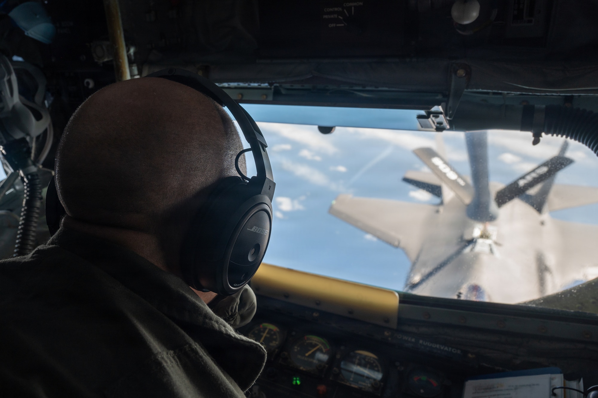 Service member refuels an aircraft above the Pacific Ocean.