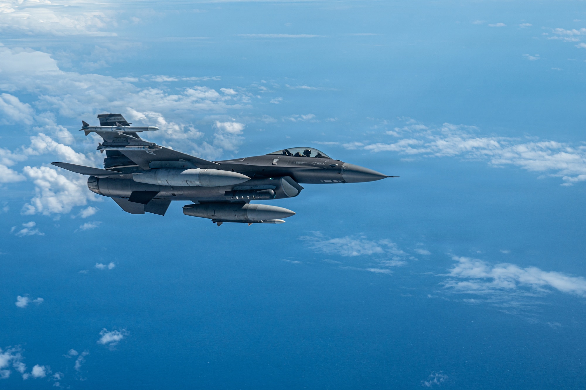 An aircraft flies over the pacific ocean.