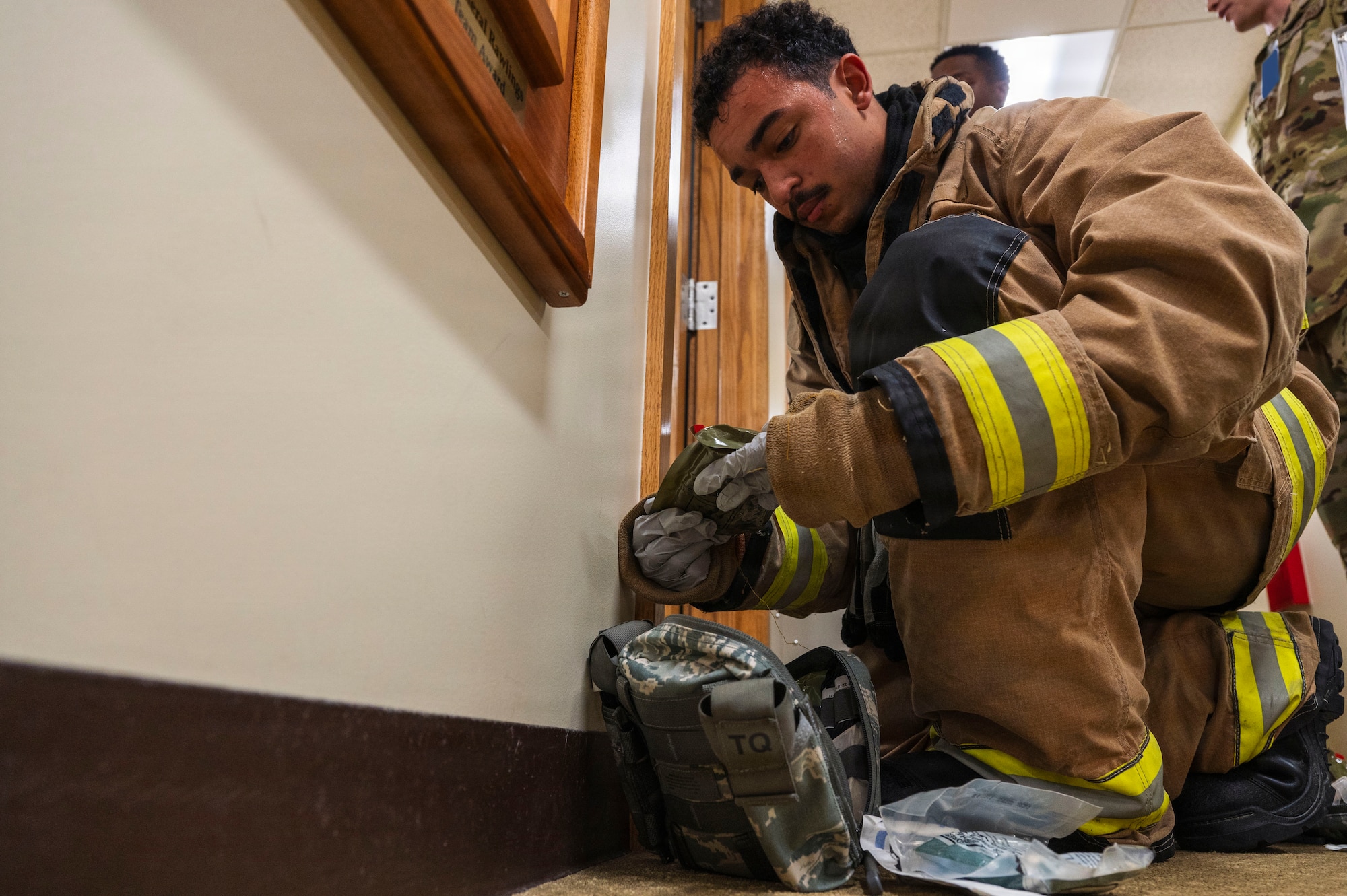 U.S. Air Force Airman 1st Class Andrew Morgan, 18th Civil Engineer Squadron firefighter, retrieves supplies from a medical pack at the 18th Communications Squadron building during a simulated active shooter exercise at Kadena Air Base, Japan, Nov. 4, 2025.