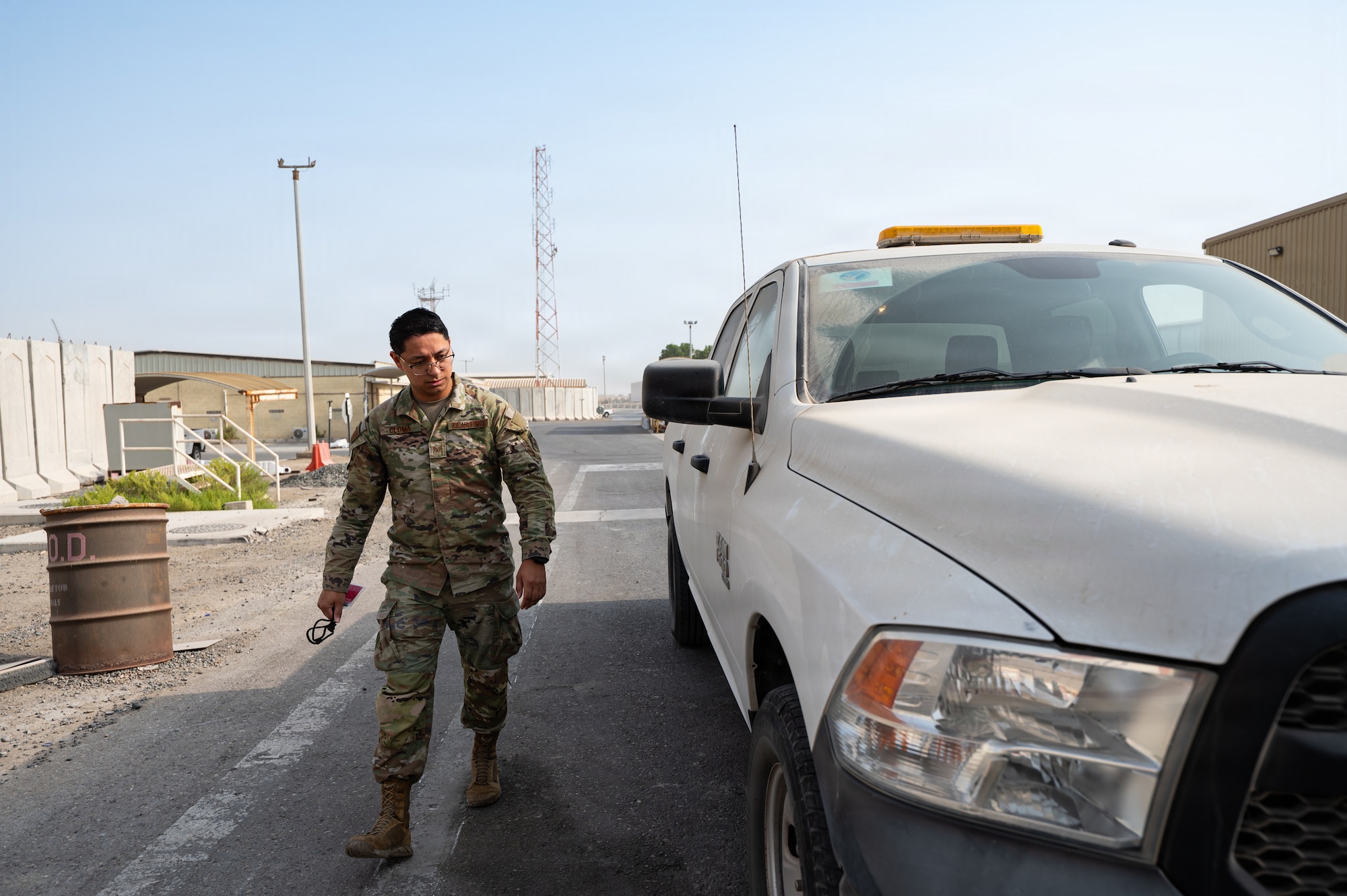 Uniformed man walks next to car