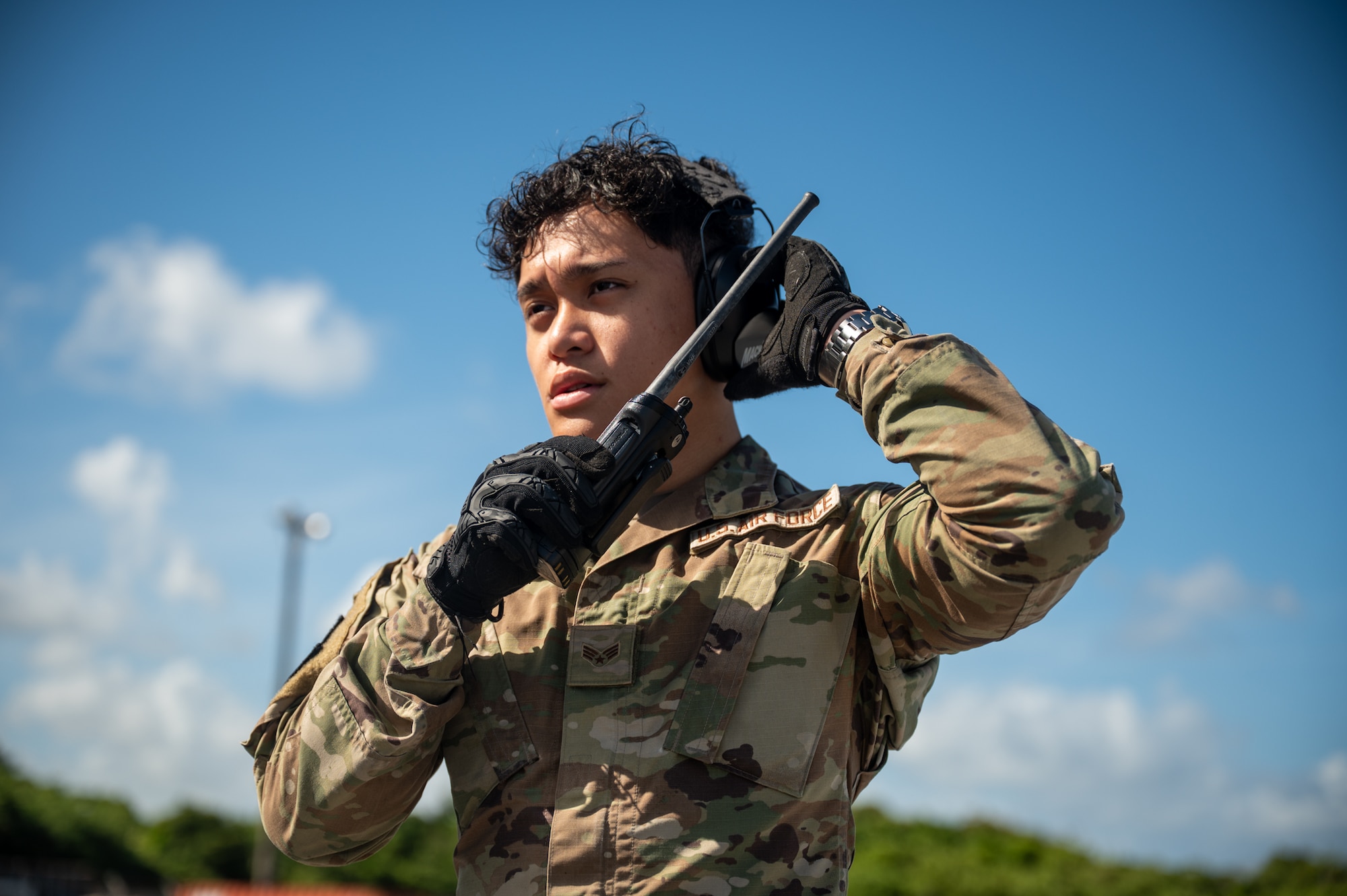A service member uses a walkie talkie.