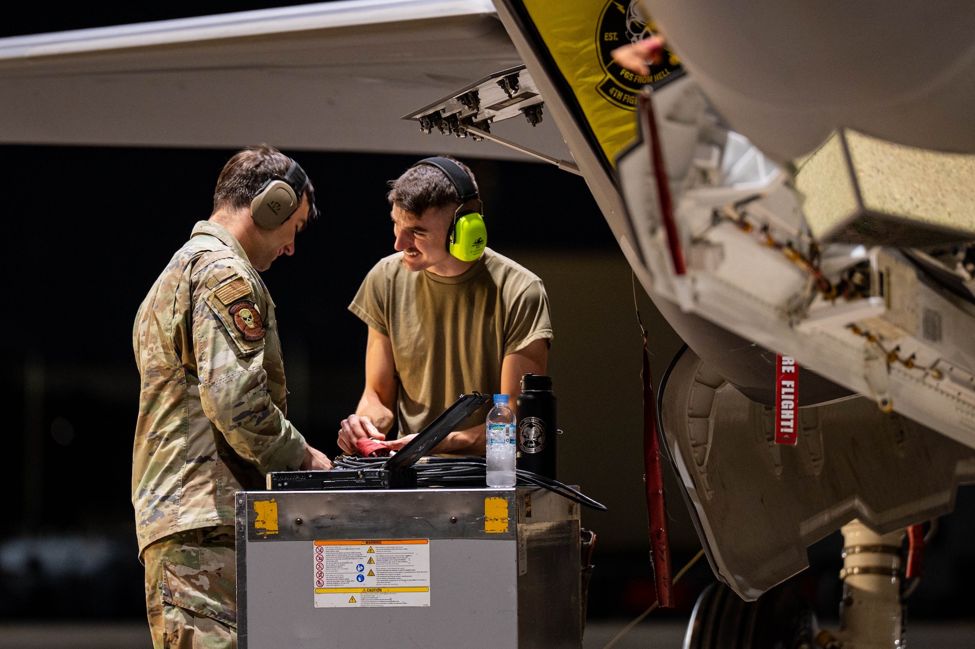 Two USAF Airmen conduct inspections on an F-35A Lightning II