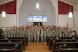 Deploying Soldiers with the 510th Regional Support Group stand for a group photo after the completion of the unit’s farewell ceremony Oct. 24, 2025, at Daenner Chapel on Daenner Kaserne. The ceremony included the singing of the German and U.S. national anthems, remarks from U.S. Army Reserve Brig. Gen. John Stanley, the commanding general of the 7th MSC, as well as the singing of “The Army Goes Rolling Along.” (U.S. Army Reserve photo by Staff Sgt. Angela O’Hearn).