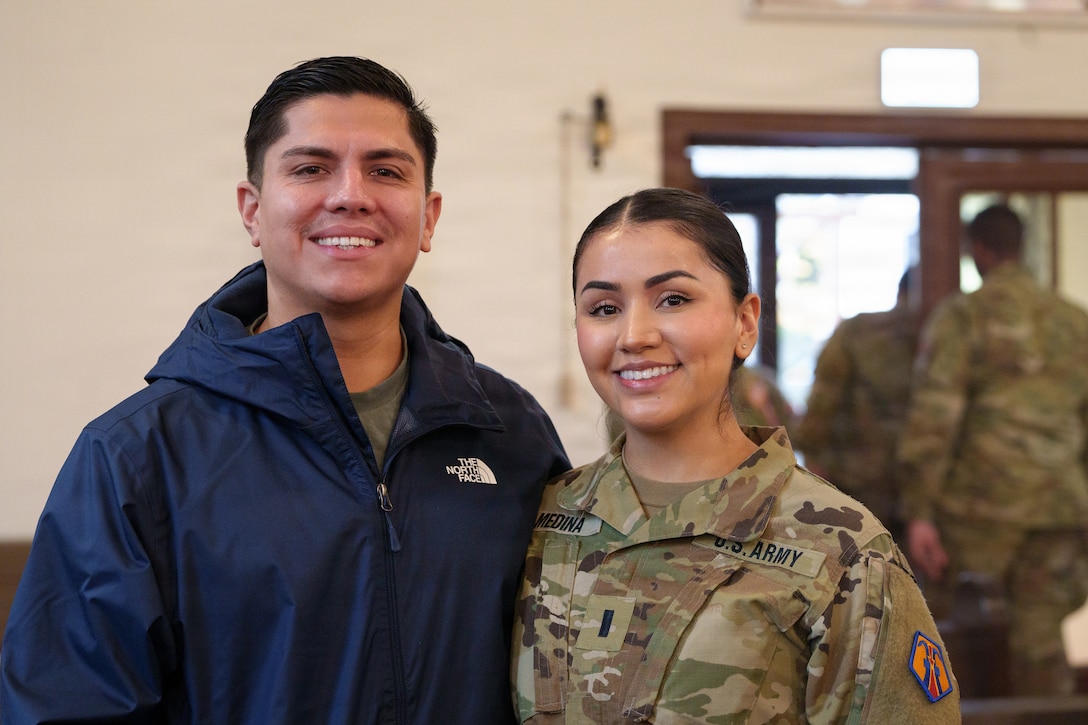 U.S. Army Reserve 1st Lt. Vanessa Medina, the 510th Regional Support Group’s Headquarters and Headquarters Company executive officer, poses for a photo besides her spouse after the conclusion of her unit’s farewell ceremony Oct. 24, 2025, at Daenner Chapel on Daenner Kaserne. The 510th RSG, 7th Mission Support Command, is scheduled to mobilize across the European theater, assuming base support and life-sustainment operation responsibilities from the 297th RSG of the Alaska National Guard, reinforcing the Army’s deterrence posture along the eastern flank. (U.S. Army Reserve photo by Lt. Col. William Wratee).