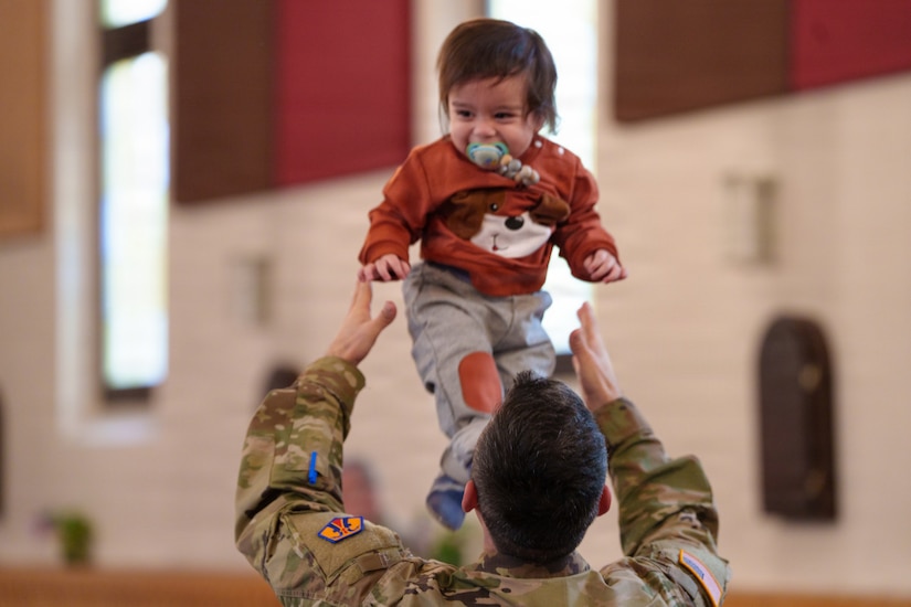 A deploying Soldier with the 510th Regional Support Group Soldier plays with his child after the conclusion of his unit’s farewell ceremony Oct. 24, 2025, at Daenner Chapel on Daenner Kaserne. The 510th RSG, 7th Mission Support Command, conducted the ceremony, inviting friends and family to attend in honor the Soldiers scheduled to deploy across the European theater. (U.S. Army Reserve photo by Lt. Col. William Wratee).