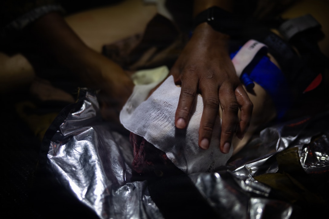 U.S. Navy Lt. Calithea Sheppard, a medical officer with 2nd Medical Battalion, 2nd Marine Logistics Group, applies a bandage to a simulated casualty during the culminating event of a Tier IV Tactical Combat Causality Care course at Marine Corps Base Camp Lejeune, North Carolina, Oct. 8, 2025. 2nd MLG became the first-ever Marine Corps command to host a Tier IV TCCC course and is now hosting its second iteration. The course trains select military service members to become proficient combat paramedics capable of providing advanced casualty care at the point of injury on the battlefield and in austere environments. Sheppard is a native of Virginia. (U.S. Marine Corps photo by Lance Cpl. Brady V. Hathaway)