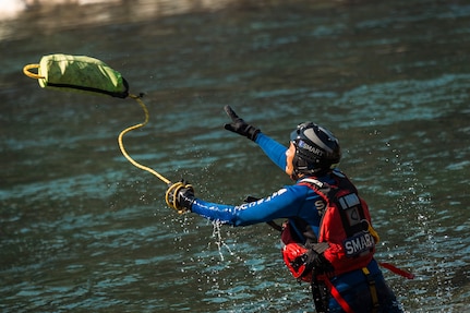 A member of the Special Malaysia Disaster Assistance and Rescue Team (SMART) tosses a water rescue throw bag to a swimmer during swift water rescue training in Spokane, Wash., Sept. 28, 2025.