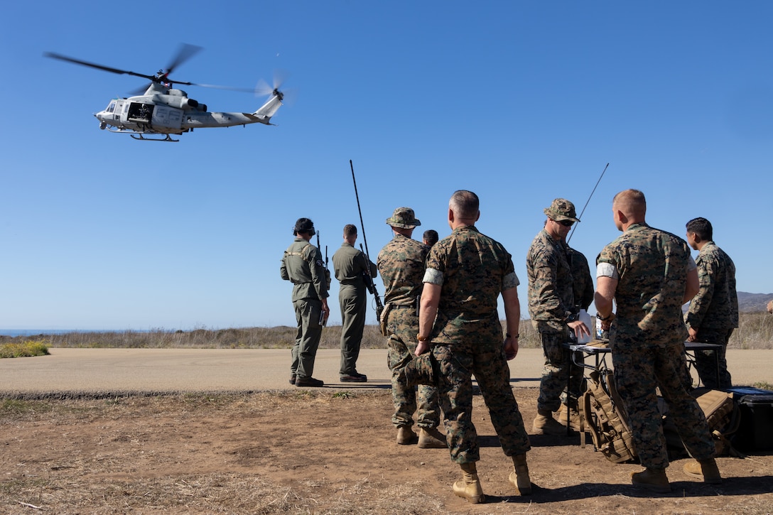 U.S. Marine Corps Col. William DeLeal II, commanding officer of I Marine Expeditionary Force Information Group, observes the departure of an UH-1Y Venom assigned to Marine Light Attack Helicopter Squadron 267, Marine Aircraft Group 39, 3rd Marine Air Wing with U.S. Marines assigned to 1st Air Naval Gunfire Liaison Company, I MIG, during familiarization training with the Link 16 Targeting Deconfliction System at Marine Corps Base Camp Pendleton, California, Oct. 30, 2025. The Link 16 Targeting Deconfliction System is a secure digital communication network that enhances real-time data exchange and improves command and control. (U.S. Marine Corps photo by Lance Cpl. Theresa Lizarde)