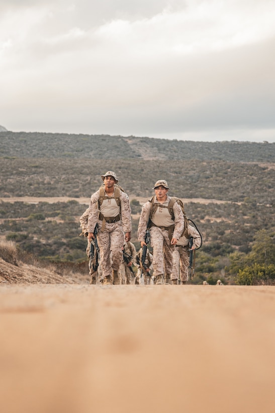 U.S. Marine Corps Cpl. Angel Camilourena, a radio operator, left, and Sgt. Julian Soriano, a satellite operator, both with 9th Communication Battalion, I Marine Expeditionary Force Information Group, hike to the next checkpoint during the inaugural Thunderstruck Communications Competition hosted by Marine Wing Communications Squadron 38, Marine Air Control Group 38, at Marine Corps Air Station Miramar, California, Sept. 10, 2025. Thunderstruck is a service-wide competition dedicated to communications Marines, showcasing the increase of resilient command and control in distributed operations. The six-mile course integrated high frequency radio, Mobile User Objective System satellite communications, and data networking tasks under expeditionary conditions, testing the tactical, technical, and physical proficiency of Marine Corps communicator. (U.S. Marine Corps photo by Lance Cpl. Fabian Ortiz)
