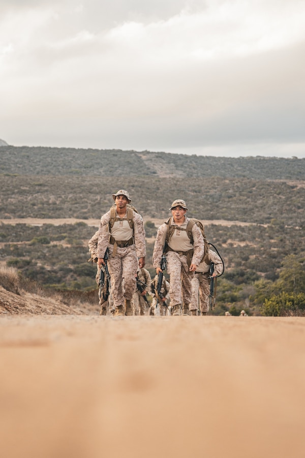 U.S. Marine Corps Cpl. Angel Camilourena, a radio operator, left, and Sgt. Julian Soriano, a satellite operator, both with 9th Communication Battalion, I Marine Expeditionary Force Information Group, hike to the next checkpoint during the inaugural Thunderstruck Communications Competition hosted by Marine Wing Communications Squadron 38, Marine Air Control Group 38, at Marine Corps Air Station Miramar, California, Sept. 10, 2025. Thunderstruck is a service-wide competition dedicated to communications Marines, showcasing the increase of resilient command and control in distributed operations. The six-mile course integrated high frequency radio, Mobile User Objective System satellite communications, and data networking tasks under expeditionary conditions, testing the tactical, technical, and physical proficiency of Marine Corps communicator. (U.S. Marine Corps photo by Lance Cpl. Fabian Ortiz)