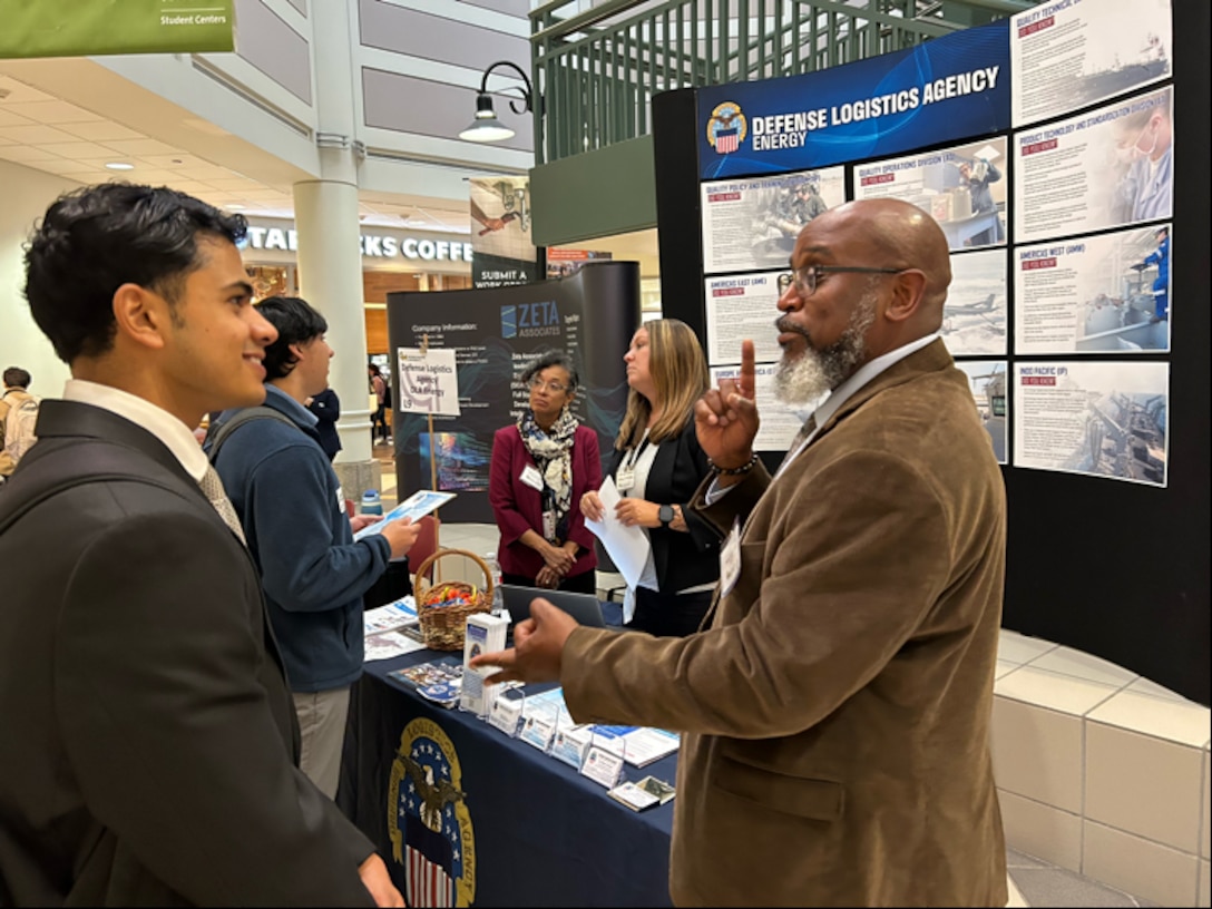 Two people speak at a job fair.