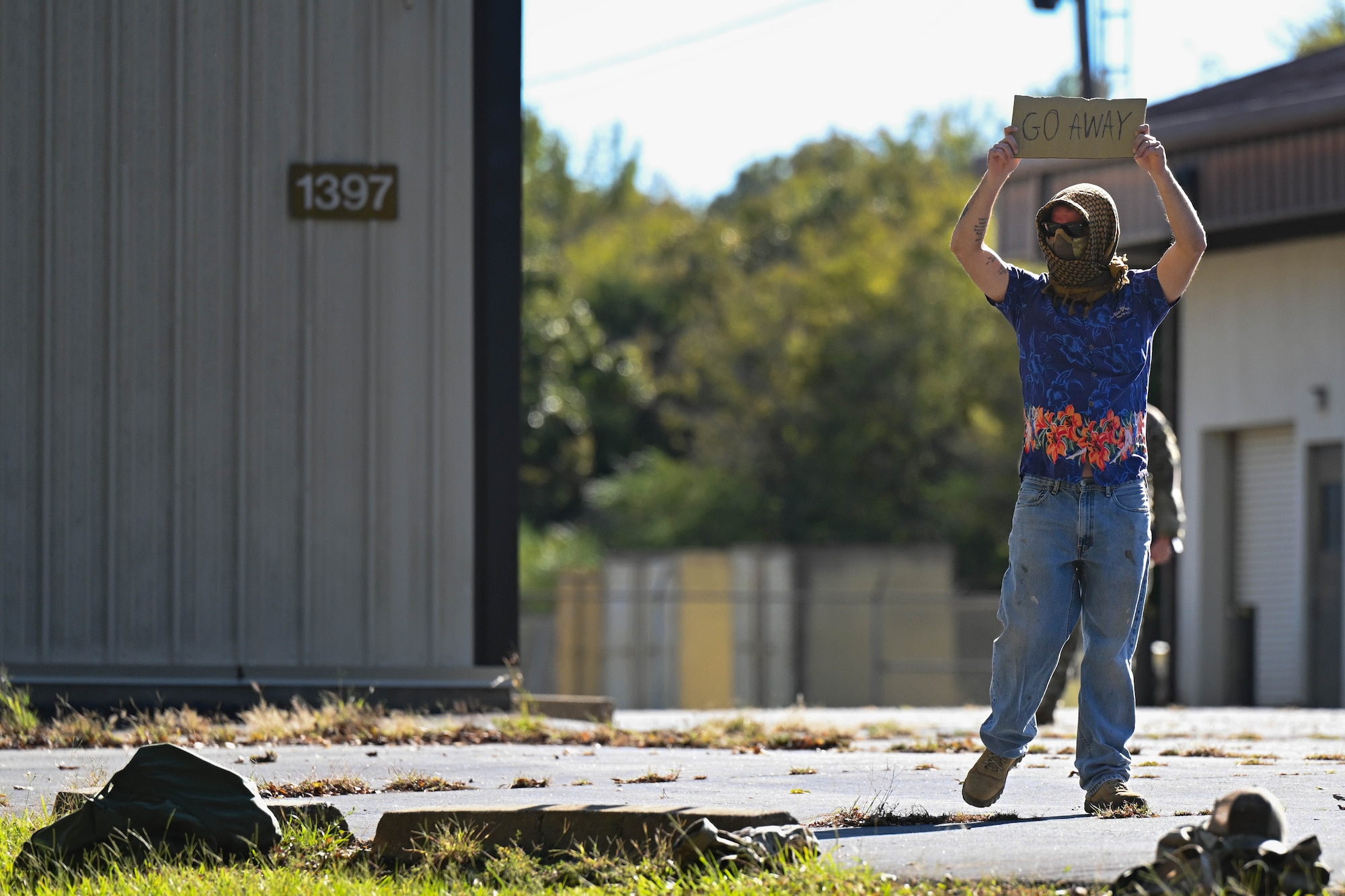 A man holds a sign in the street.