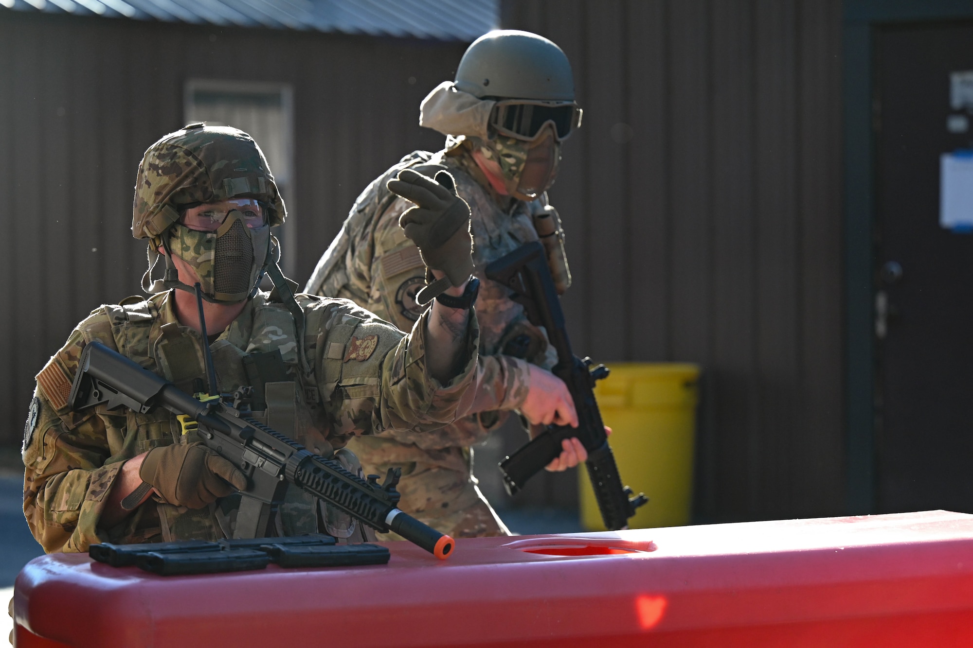 Two men in uniform defend a post during an exercise.