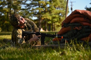 A man in uniform lays in the grass.