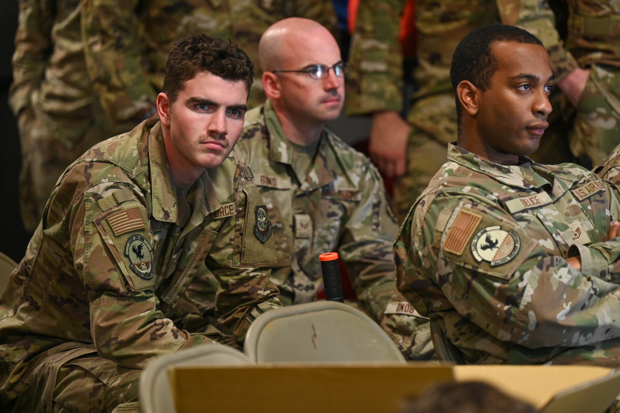 A group of men sit in a classroom.