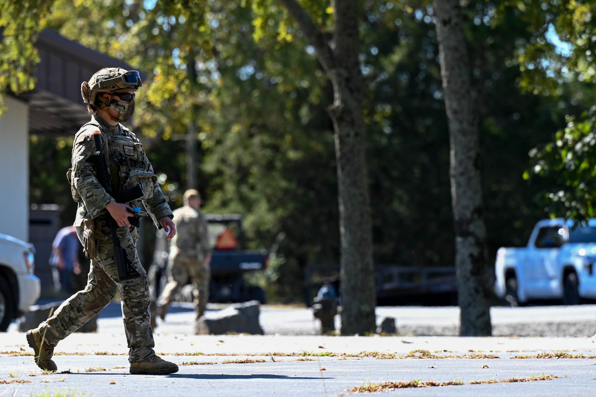 A woman and uniform walks on the street.