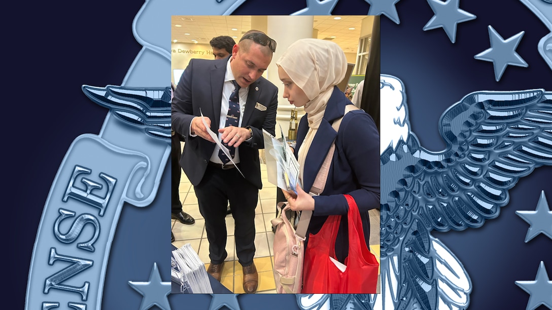 Two people are speaking during a job fair.