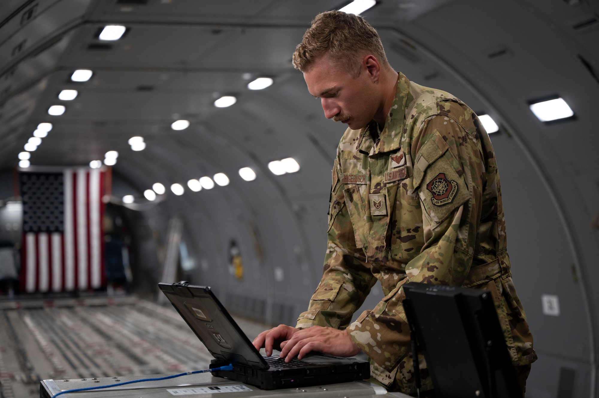 U.S. Air Force Staff Sgt. Michael Hagebusch, a mission system operator assigned to the 22nd Operations Support Squadron at McConnell Air Force Base, Kansas, performs a demonstration of a Taclane Augmented ROBE System onboard a KC-46 Pegasus at Andersen Air Force Base, Guam, during the Air Force’s 2025 Department-Level Exercise, July 24, 2025. The Taclane Augmented ROBE System allows ground crew, other aircraft and Air Operations Centers to be better connected, enabling an increased level of joint integration to operate and survive within contested environments. The DLE series encompasses all branches of the Department of Defense, along with allies and partners, employing more than 400 Joint and coalition aircraft and more than 12,000 members at more than 50 locations across 3,000 miles. (U.S. Air Force photo by Staff Sgt. Dalton Williams)