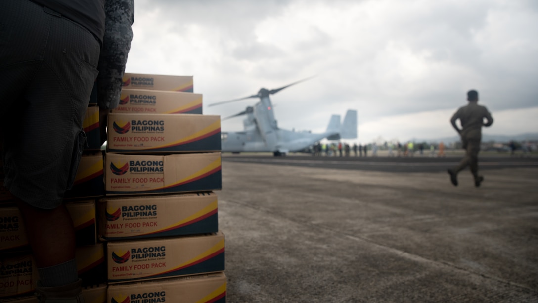 Armed Forces of the Philippines service members and U.S. Marines assigned to Marine Rotational Force-Southeast Asia, I Marine Expeditionary Force, unload palletized family food packs from a U.S. Marine Corps MV-22B Osprey attached to Marine Medium Tiltrotor Squadron (VMM) 262, Marine Aircraft Group 36, 1st Marine Aircraft Wing, in support of foreign disaster relief operations at Virac, Philippines, Nov. 13, 2025.