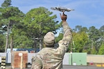 Soldier launching a hand-held, quad-copter drone.