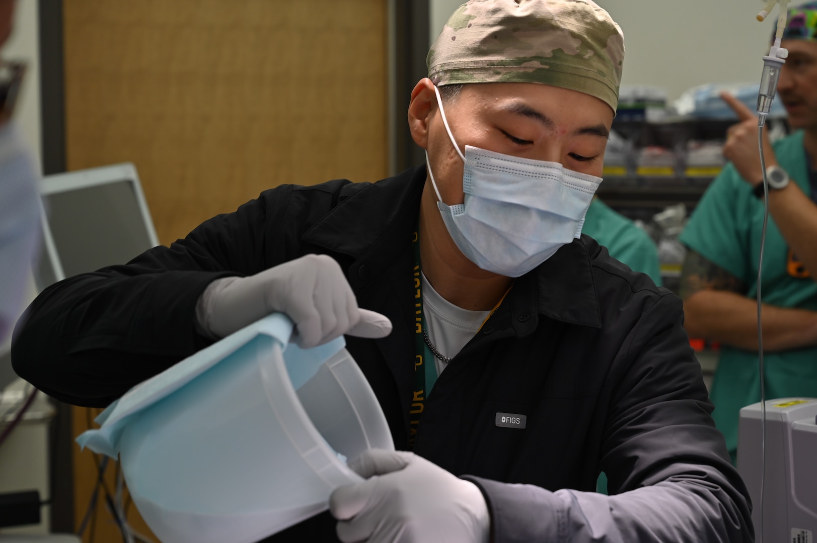 Capt. Jung adds ice to the mannequin as part of a malignant hyperthermia training exercise, helping staff practice rapid cooling techniques.