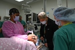 Capt. James Jung, a student nurse anesthetist, injects medication into the IV while a nurse maintains the airway on a training mannequin during a malignant hyperthermia drill at Carl R. Darnall Army Medical Center, as staff members look on.