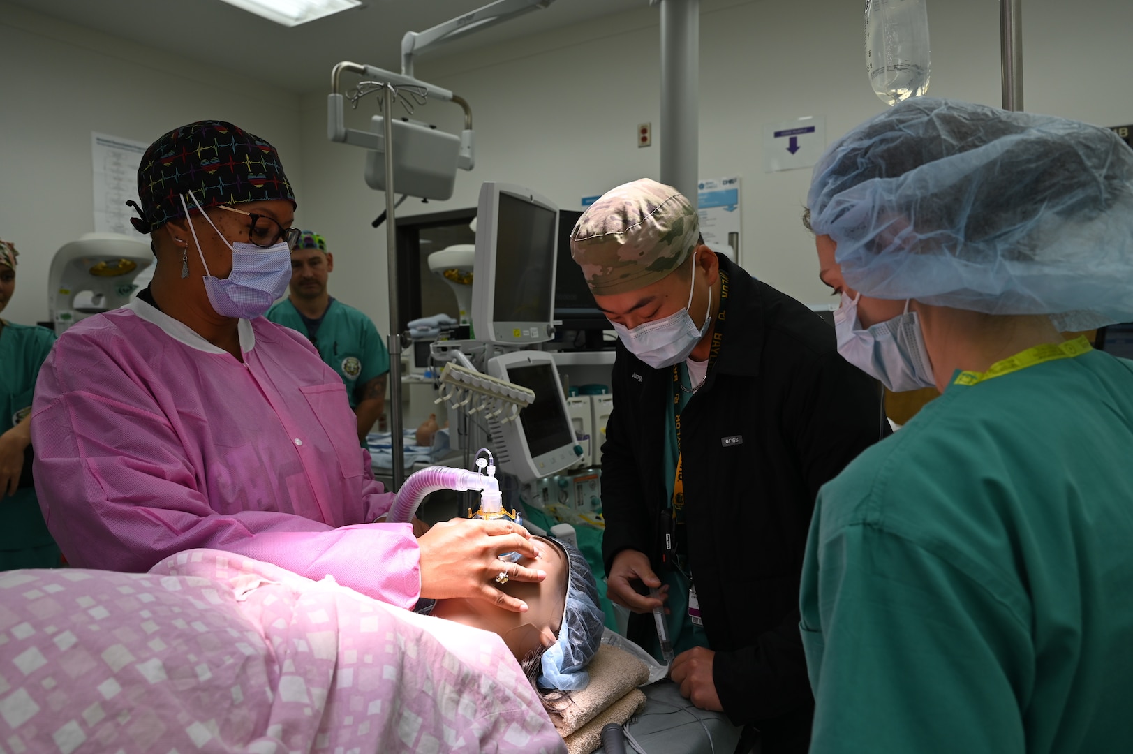 Capt. James Jung, a student nurse anesthetist, injects medication into the IV while a nurse maintains the airway on a training mannequin during a malignant hyperthermia drill at Carl R. Darnall Army Medical Center, as staff members look on.