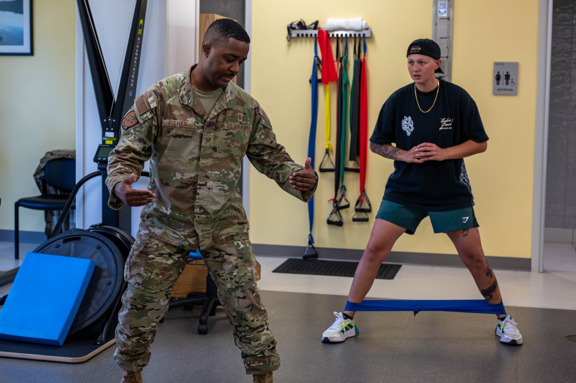 U.S. Air Force Tech. Sgt. Brandon Fisher, 325th Operational Medical Readiness Squadron human performance flight chief, demonstrates exercises for a patient at Tyndall Air Force Base.