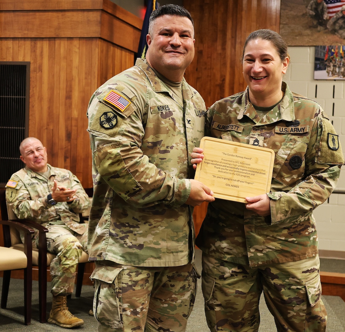 Col. Shawn Nokes presents Sgt. 1st Class Kayla Alberstett, a senior instructor in the 92G (culinary specialist) program, with the Gordon Ramsey award.