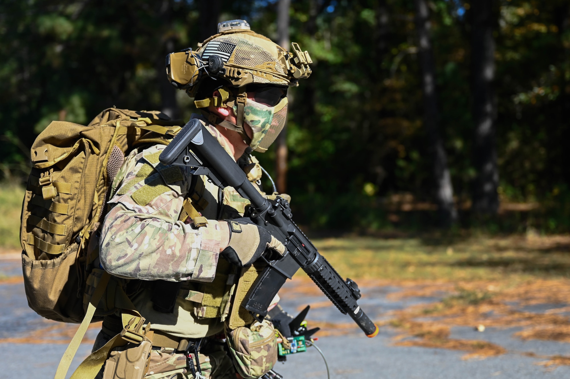 A man in uniform runs with his gear.