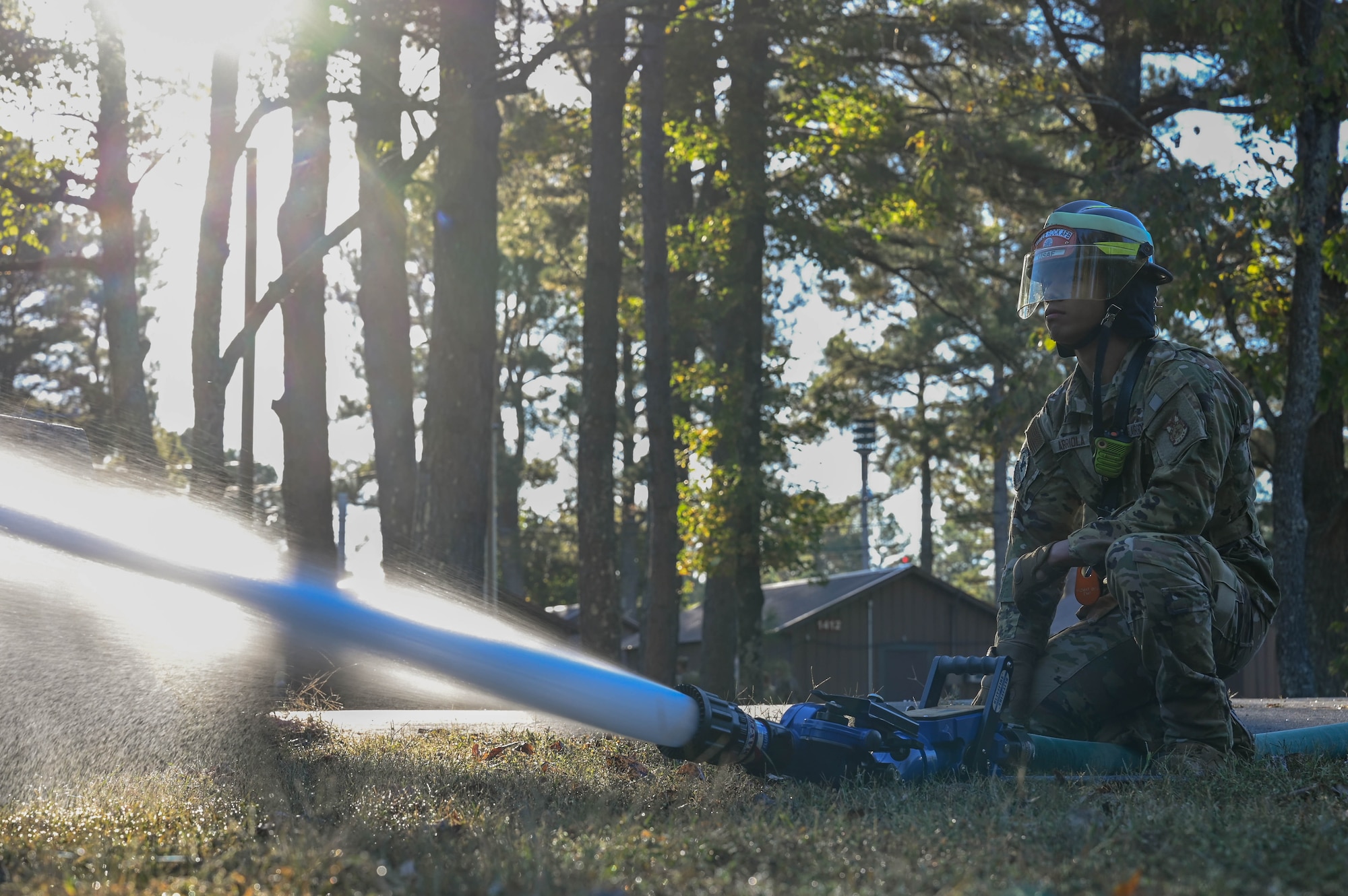 A man in uniform operates a fire hose.
