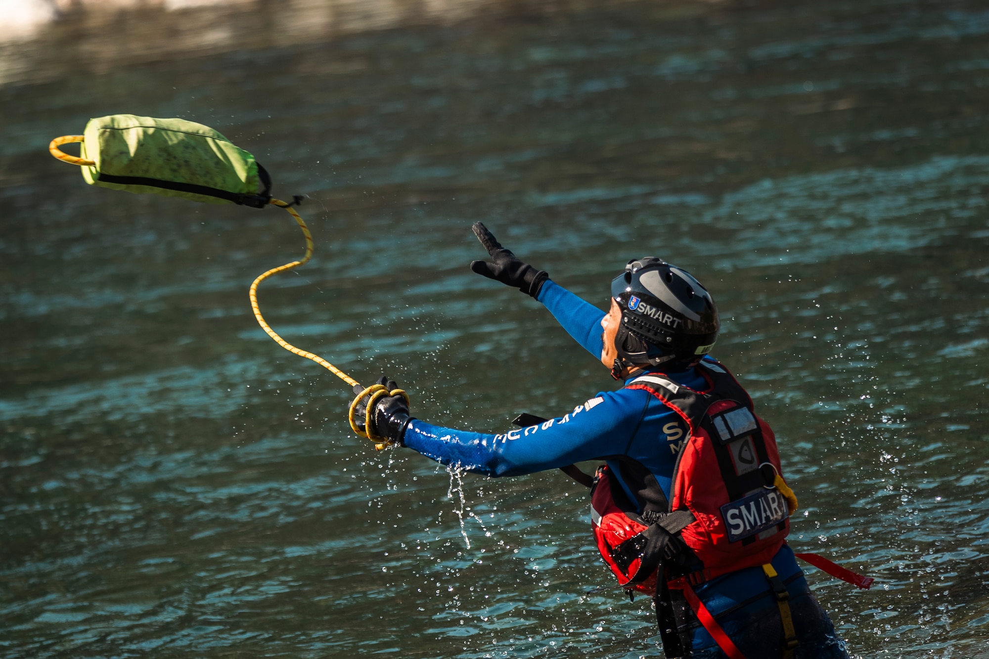 A member of the Special Malaysia Disaster Assistance and Rescue Team (SMART) tosses a water rescue throw bag to a swimmer during swift water rescue training in Spokane, Wash., Sept. 28, 2025.