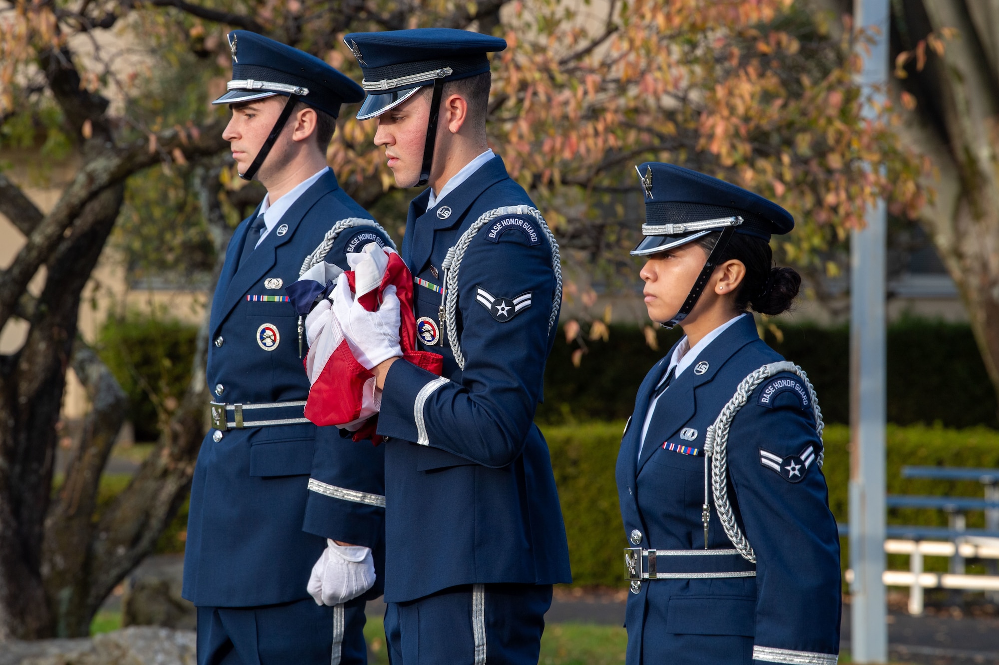 Three military honor guardsmen conduct a U.S. flag folding.