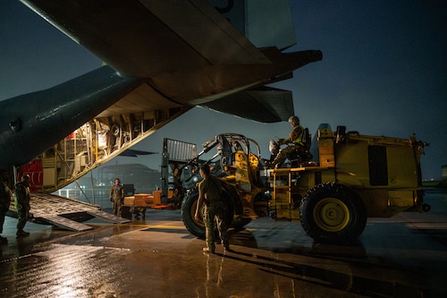 Military members load cargo onto a C-130J aircraft.