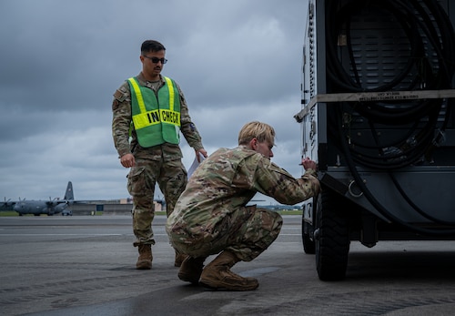 A pair of Airmen check equipment.