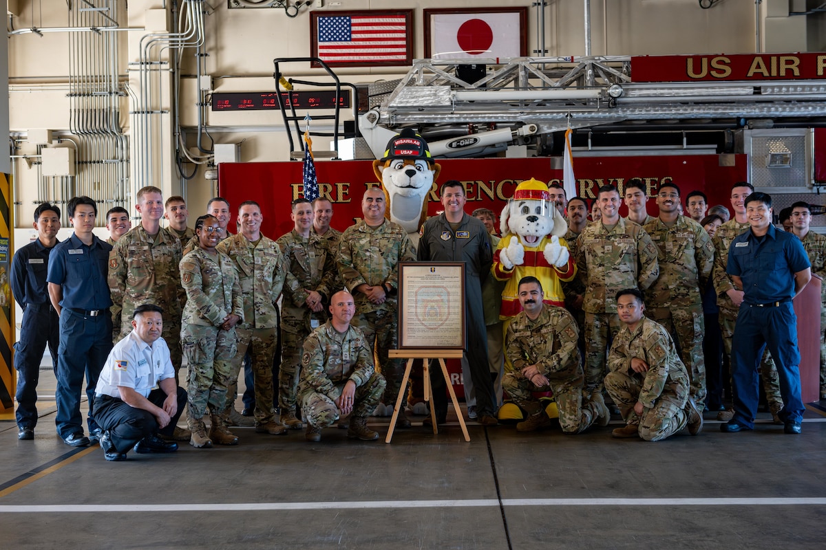 U.S. Air Force members assigned to the 35th Fighter Wing pose for a photo with a signed proclamation during the Fire Prevention Week 2025 opening ceremony.