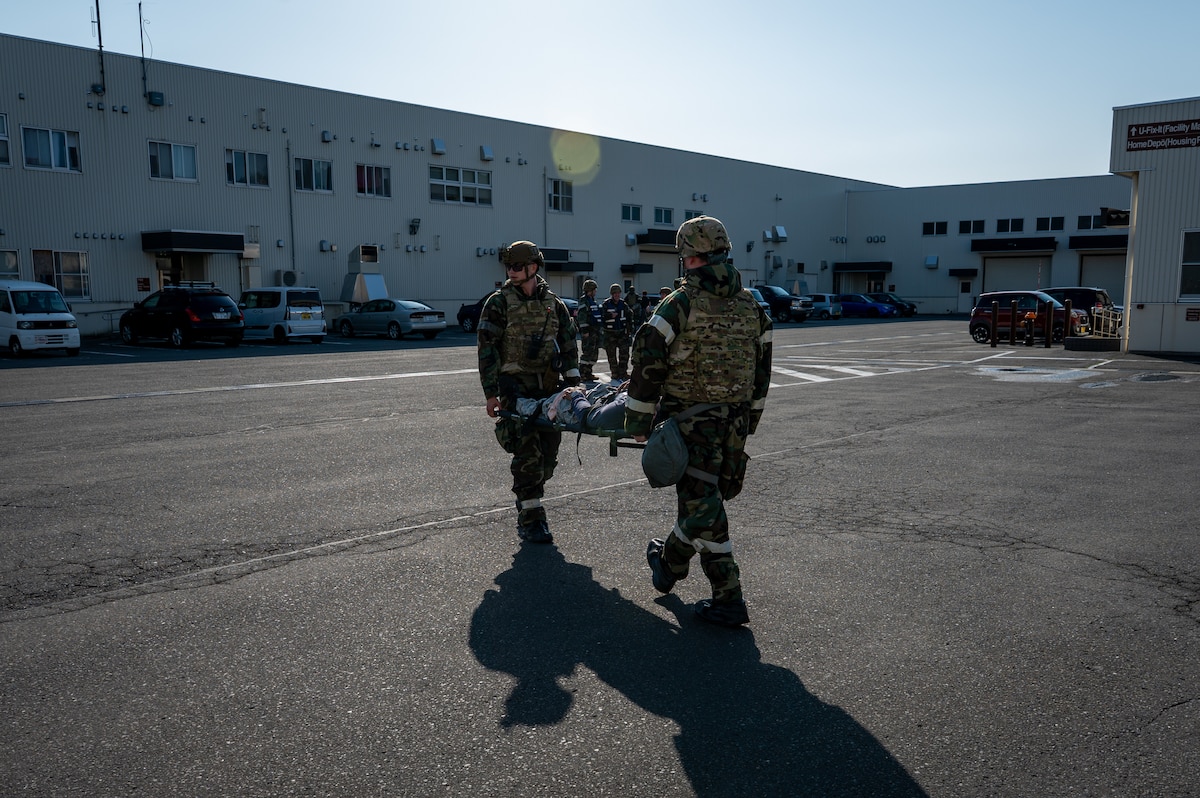 U.S. Air Force Airmen assigned to the 35th Civil Engineer Squadron transport a simulated injured member during Exercise Beverly Sunrise 26-1 (BS26-1) at Misawa Air Base, Japan, Oct. 15, 2025. Exercises like BS26-1 ensure 35th Fighter Wing personnel remain proficient in lifesaving skills that enable mission continuity and operational success. (U.S. Air Force photo by Senior Airman Brittany Russell)