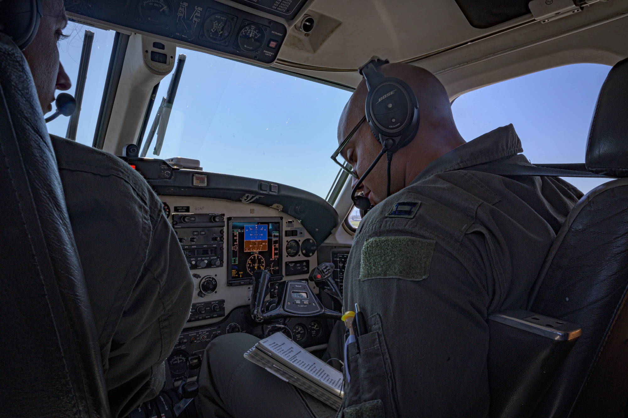 A military pilot does pre-checks inside a C-12 aircraft.